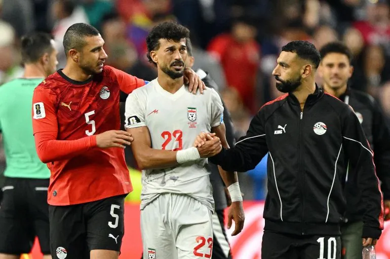 Egypt's Mohamed Salah shakes hands with Iran's Ramin Rezaeian.